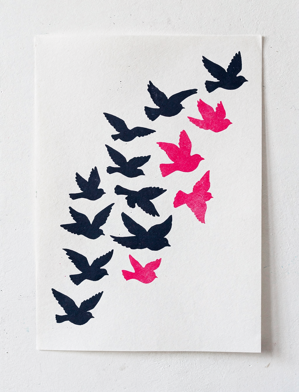 Migration Is Not a Crime poster: flock of navy and pink bird silhouettes (placeholder artwork)