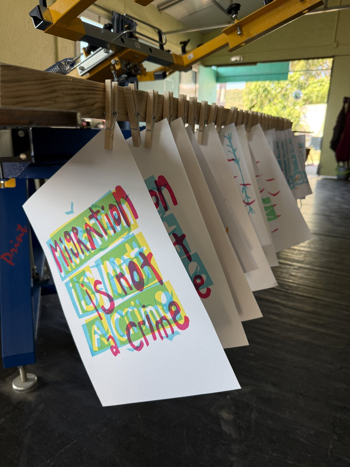 Freshly printed posters drying on a line