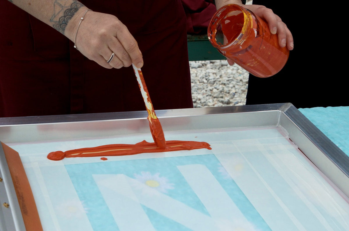 Pouring orange ink onto a screen