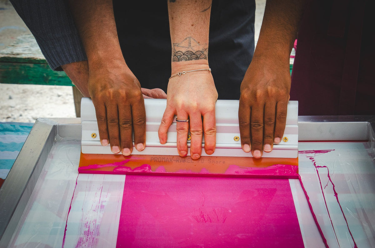 Pulling a squeegee across a magenta screen